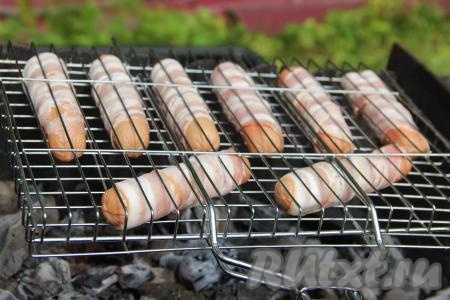 Жарить сосиски в беконе, часто переворачивая, минут 5-7 (до лёгкого подрумянивания бекона).