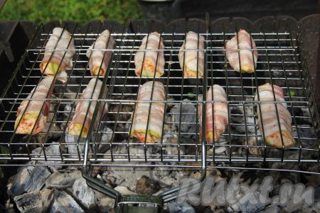 Кабачки, завёрнутые в бекон, разложить на решётке и поместить на мангал с горячими углями (угли должны быть раскалёнными, но прямого огня быть не должно).