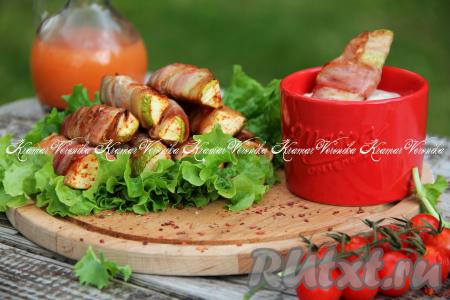 Переложить нежные, аппетитные кабачки в беконе с решётки мангала на тарелку и подать к столу в горячем виде, дополнив соусом на ваш выбор.