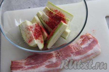 Поместить кабачки, нарезанные на брусочки, в миску, добавить специи (я взяла паприку) и соль, перемешать и оставить минут на 10. Затем откинуть на дуршлаг, чтобы удалить выделившийся сок. Разделить на полоски бекон.