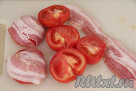 Разрезать помидоры на две части, удалить плодоножку. Обернуть каждую половинку помидора в полоску бекона.