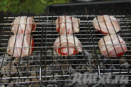 К моменту жарки помидоров в мангале должны быть очень горячие угли, но прямого огня быть не должно. Половины помидоров, завёрнутые в бекон, выложить на решётку и поместить на подготовленный мангал.