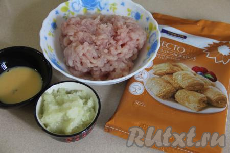 Подготовить продукты для приготовления пирога с фаршем из слоёного бездрожжевого теста. Луковицу почистить. Мясо (у меня - куриное филе) промыть водой, обсушить. Луковицу и мясо пропустить через мясорубку. Покупное слоёное бездрожжевое тесто разморозить при комнатной температуре.