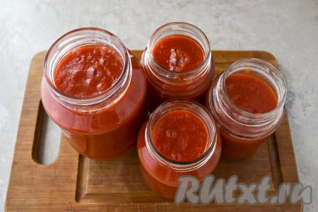 Заранее простерилизуйте банки (простерилизовать можно в микроволновке, духовке или в кастрюле над паром). Крышки тоже нужно будет заранее прокипятить в течение 3 минут с момента закипания воды и оставить в кипятке до закатки. В простерилизованные банки разлейте горячий кетчуп и сразу закрутите крышками.
