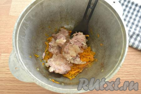 К обжаренным овощам добавляем тушёнку, перемешиваем, разбивая кусочки мяса лопаткой.