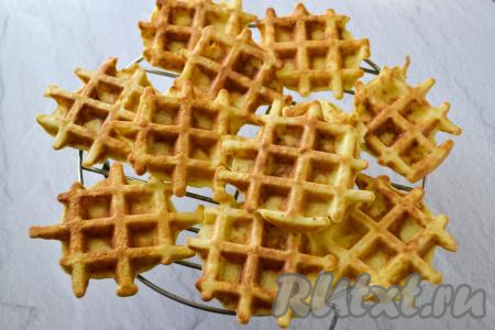 Готовые вафли переложите на решётку. Рисовая мука имеет особенность оседать на дно посуды, поэтому перед жаркой очередной порции оладий обязательно перемешивайте тесто в миске. Постепенно испеките все кабачковые вафли (у меня получилось 12 штук).