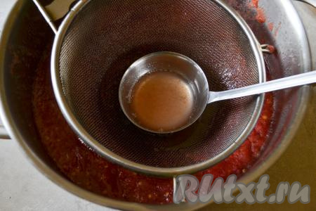 По прошествии времени густая томатная масса поднимается вверх, а прозрачный сок образуется под ней. Опустите сито в кастрюлю с томатной массой. Когда сито с небольшим нажатием опускается на густую массу, сквозь неё просачивается сок и собирается в сите. Половником отчерпайте сок, который окажется в сите.