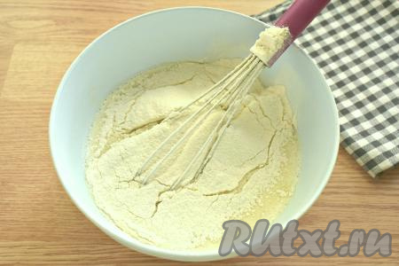 Далее в молочно-яичную смесь частями просеиваем пшеничную муку, каждый раз полностью вмешивая её венчиком.