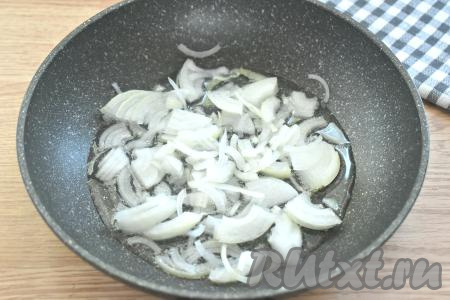 Очищаем лук и морковь. Луковицу нарезаем на четверть кольца (или полукольца). Прогреваем в сковороде растительное масло, выкладываем лук и на среднем огне, периодически перемешивая, обжариваем его 3 минуты.