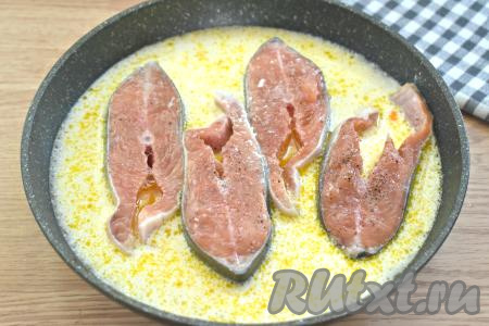 Практически полностью заливаем кусочки горбуши сметанным соусом и ставим сковороду на сильный огонь.