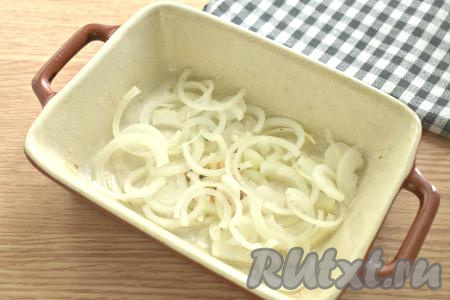 Очищаем&nbsp; лук и нарезаем его на тонкие полукольца. Дно и бока формы для запекания смазываем одной столовой ложкой растительного масла. На дно формы ровным слоем выкладываем нарезанный лук.