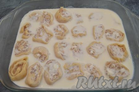 Для приготовления сметанного соуса соединить сметану и воду комнатной температуры, посолить по вкусу и перемешать. Влить сметанный соус в форму с ленивыми пельменями, поливая пельмени и сверху. Пельмени должны быть покрыты соусом чуть больше, чем на 2/3.