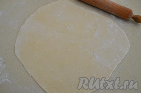 По прошествии 20-30 минут разделить тесто на 2 равные части. На припылённом мукой столе раскатать одну часть теста в прямоугольный тонкий пласт (толщиной около 2 миллиметров).