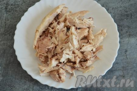 В первую очередь сварим мясной бульон, для этого нужно кусочки курицы на кости выложить в кастрюлю, влить 2-2,5 литра воды и поставить на огонь. После закипания, убрав пену, варить бульон минут 25. Затем снять кастрюлю с огня. Достать мясо из бульона, дать ему немного остыть и отделить от костей. Бульон, если нужно, процедить. Выложить обратно в бульон отделённое от костей мясо.