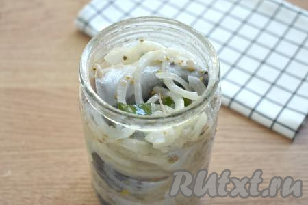 Кусочки скумбрии, покрытые смесью масла, лимонного сока и специй, поочерёдно с луком выкладываем в банку (я использовала стеклянную банку объёмом 0,7 литра). Остатки масляно-лимонной смеси тоже выливаем в банку. Накрываем банку со скумбрией крышкой и отправляем в холодильник на сутки.