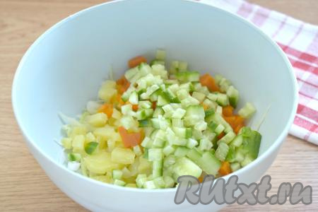 Свежий огурец моем, срезаем кончики с двух сторон, а затем нарезаем его на небольшие кубики, перекладываем в миску с нарезанными овощами.