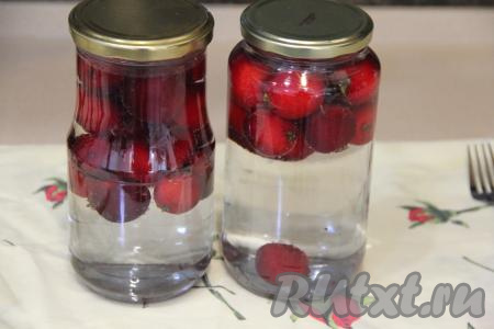 Вскипятить в чайнике примерно 2 литра воды, влить в банки с райскими яблоками, заполняя полностью банки. Накрыть банки крышками и оставить на 20 минут.