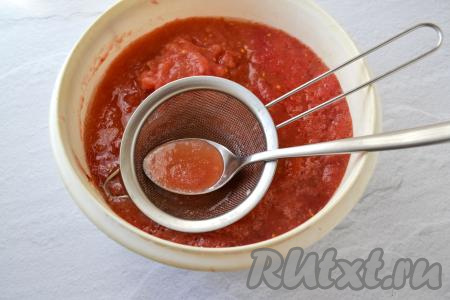 За эти часы томатная масса разделится на жидкую часть (сок) и густую (мякоть). Опустите металлическое сито в томатную массу. Прозрачный томатный сок будет собираться в ситечке. С помощью столовой ложки отчерпайте сок из сита в отдельную ёмкость.