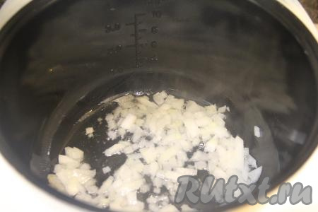 В чашу мультиварки влить растительное масло, выставить режим "Жарка". Лук мелко нарезать, выложить в чашу и обжаривать его 2-3 минуты (до прозрачности), не закрывая крышку мультиварки и периодически перемешивая.