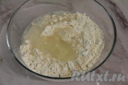 Влить в муку горячую воду и растительное масло.