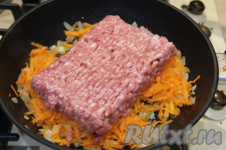После того как морковь станет достаточно мягкой, выложить в сковороду фарш и обжаривать его с овощами минут 10, тщательно разбивая лопаткой комочки фарша.