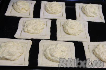 Творожно-лимонную начинку зрительно разделить на 8 частей (по количеству слоек). В центр каждого квадрата, немного отступив от разрезов, выложить часть начинки.