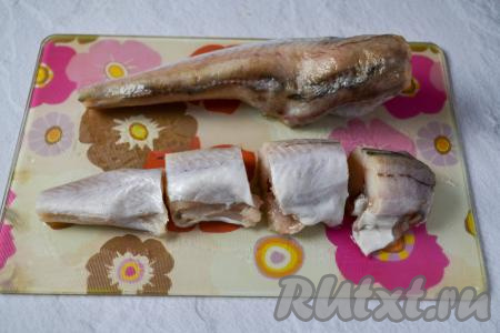 Разрежьте тушки минтая на порционные кусочки.