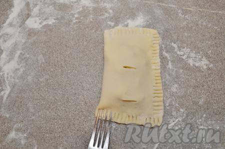 Стороной с надрезами накрыть сторону с начинкой. Тщательно скрепить края получившейся слойки с помощью вилки. Если вилка будет сильно липнуть к тесту, тогда обмакивайте вилку в муку.