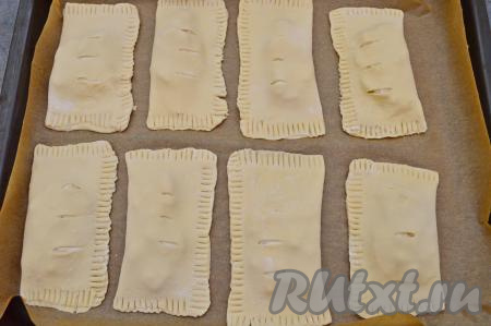 Сформированную слойку с творогом и персиком переложить на противень, застеленный пергаментом. Аналогично сформировать и выложить на противень ещё 7 слоек.