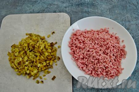 Маринованные огурцы и варёную колбасу тоже нарезать на мелкие кубики.