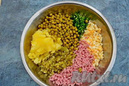 Остывшую картошку очистить от кожуры и нарезать мелко. С консервированного горошка слить жидкость. В глубокой миске соединить горошек, зелёный лук, колбасу, яйца, картошку и огурцы.