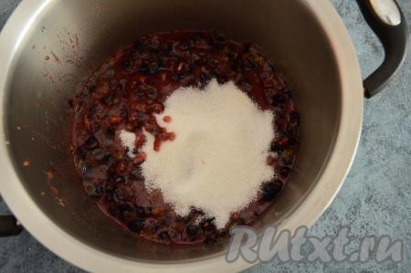 Затем в кастрюлю с чёрной смородиной всыпать сахар и перемешать.