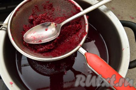 Процедить слегка остывший морс из чёрной смородины через сито. Ягоды, оставшиеся в сите, перетереть через сито в кастрюлю с процеженным морсом. После перетирания ягод в сите останется совсем немного практически сухого жмыха, который можно выбросить.