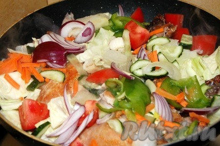 Через 10 минут, когда курочка подрумянится, нарезанные овощи добавить в сковороду к курице, влить 1 стакан горячей воды и закрыть крышкой, не мешая ничего. Не забыть рагу посолить и поперчить.