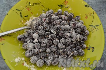 Чёрную смородину смешать с половиной столовой ложки муки. Ягоды обваливаются в муке для того, чтобы они не оседали на дно пирога во время выпечки.