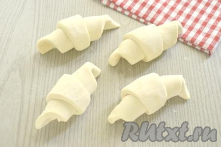 Начиная со стороны с начинкой, сворачиваем каждую заготовку в рулет так, чтобы "хвостик" (вершина треугольника) оказался внизу.