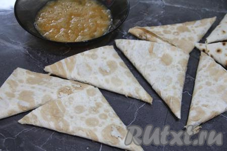 В результате складывания полоски с начинкой получится конвертик в виде треугольника. Аналогично сформировать все треугольные конверты из оставшихся полосок лаваша и начинки. Яйца вбить в миску, взбить вилкой, по желанию, слегка посолить.