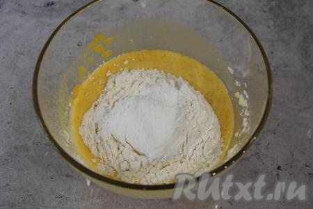В тыквенно-яично-масляную массу всыпать разрыхлитель и чуть больше половины просеянной муки, перемешать лопаткой (или столовой ложкой) до однородности.