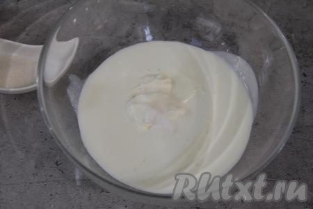 Влить кефир в объёмную миску, добавить сметану, всыпать соду, тщательно перемешать венчиком, оставить на 3-5 минут (в течение этого времени сода погасится в смеси сметаны и кефира, на поверхности смеси появятся пузырьки).