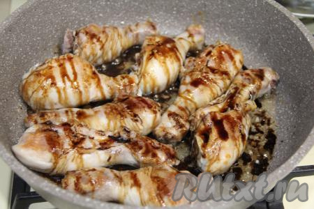 К обжаренным куриным ножкам влить соус "Терияки", убавить огонь до минимума, накрыть сковороду крышкой. Тушить куриное мясо минут 30, периодически переворачивая.