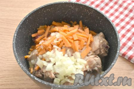 К обжаренным кусочкам курицы добавляем мелко нарезанный лук и морковку, нарезанную на брусочки, аккуратно перемешиваем. Обжариваем курицу с овощами минут 5 на среднем огне, иногда помешивая.