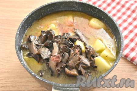 Добавляем ещё немного соли, молотые специи. Вливаем 200-250 миллилитров тёплой воды, перемешиваем. Вода должна покрыть ингредиенты практически полностью. Даём воде закипеть на достаточно сильном огне и, убавив огонь, тушим картошку с курицей и грибами под крышкой 20-25 минут (кусочки картофеля должны полностью приготовиться, то есть они будут легко прокалываться вилкой).