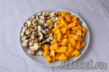 Почистите тыкву от кожуры, удалите семечки с волокнами. Баклажан очистите от кожуры. Свежую зелень вымойте и обсушите. 200 грамм очищенной тыквы и 200 грамм очищенного баклажана нарежьте на небольшие кубики.
