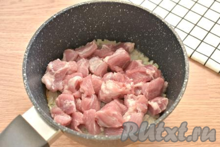 Вымытую свинину нарезаем на небольшие кусочки, добавляем к обжаренному луку, перемешиваем и готовим, иногда перемешивая, 10 минут.