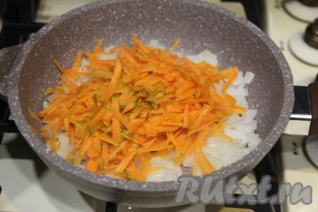 К обжаренному луку выложить морковку, натёртую на крупной тёрке, сразу перемешать и обжаривать, иногда помешивая, минут 5 (до мягкости моркови), убрать с огня.