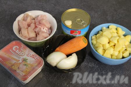 Подготовить продукты для приготовления сырного супа с зелёным горошком. Картошку, лук, чеснок и морковку почистить. Картошку нарезать на средние кубики, залить водой, чтобы картошка не почернела. Куриное филе нарезать на средние кусочки. Я варила суп с консервированным горошком. Но отличным будет суп и со свежим или замороженным зелёным горошком.