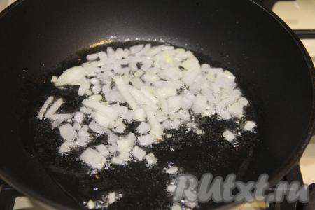 Вначале приготовим начинку для пирога. Для этого в сковороду с разогревшимся растительным маслом нужно выложить мелко нарезанный лук и обжарить его в течение 3-4 минут, иногда помешивая, на среднем огне.