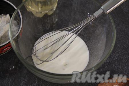 Теперь замесим заливное тесто, для этого в миску нужно влить кефир комнатной температуры (для того чтобы кефир был комнатной температуры, его можно подогреть в микроволновке в течение 20 секунд или заранее достать из холодильника), всыпать соду. Перемешать венчиком кефир с содой и оставить на 3-4 минуты, за это время масса запузырится и увеличится в объёме.