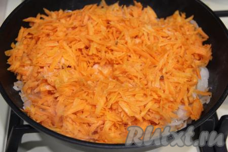 В сковороду влить растительное масло, разогреть, выложить полукольца лука и обжарить на среднем огне, иногда помешивая, в течение 7 минут, затем добавить морковку, перемешать.