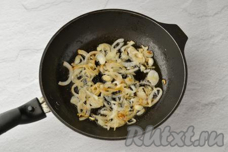 Разогрейте сковороду с растительным маслом и выложите в неё лук. На огне выше среднего обжарьте лук, иногда помешивая, до лёгкого золотистого цвета.